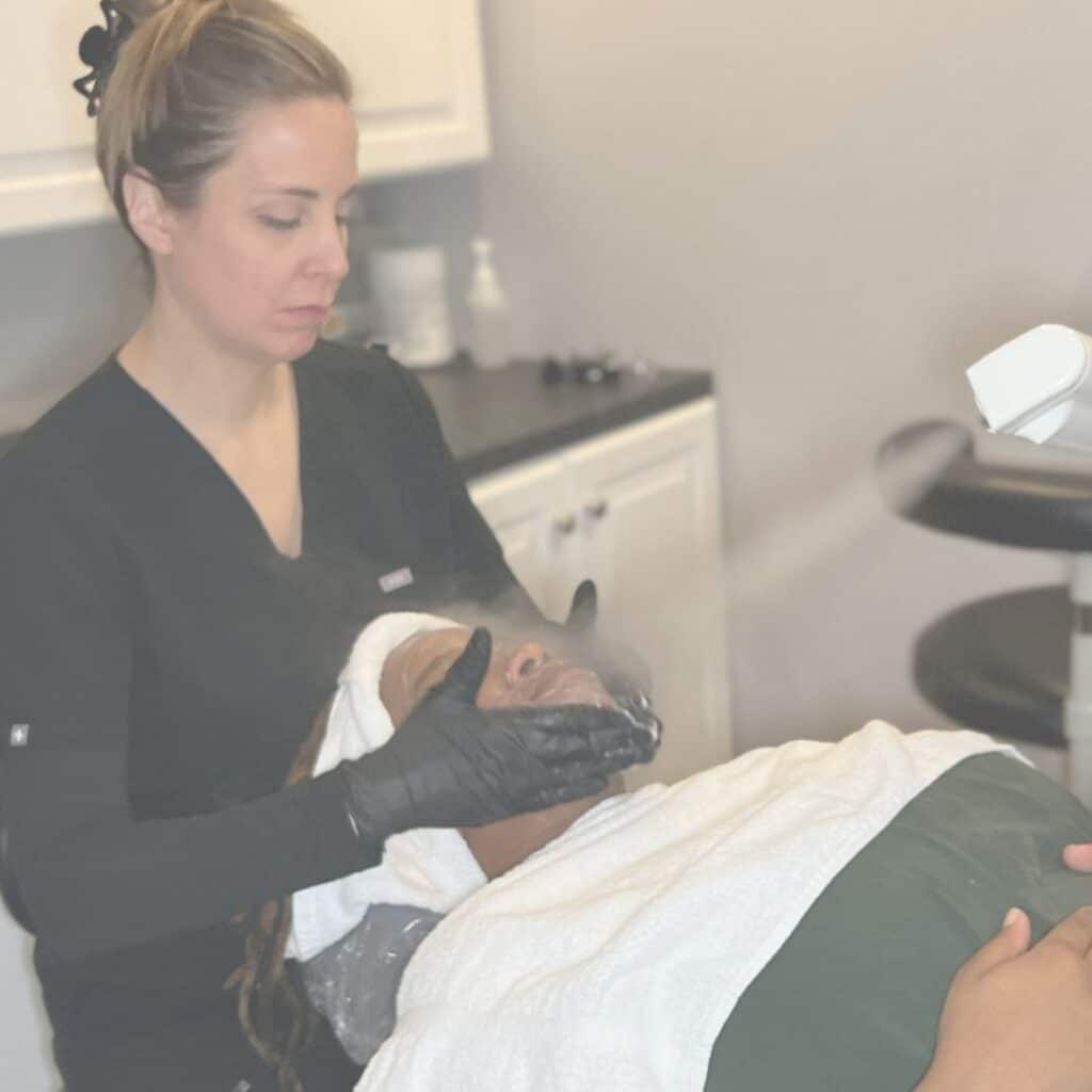 Image shows Aesthetician Angela Timm doing a facial on a client at Taylor Drive Facial Aesthetics in Sheboygan, WI